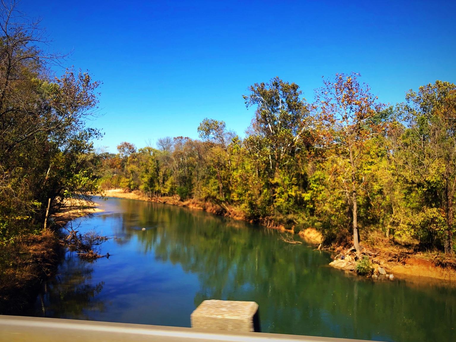 A creek winding through fall foliage near Bella Vista